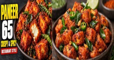 Crispy restaurant-style Paneer 65 garnished with fried curry leaves, green chillies, and lemon wedges.