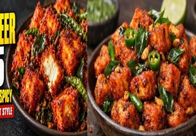 Crispy restaurant-style Paneer 65 garnished with fried curry leaves, green chillies, and lemon wedges.